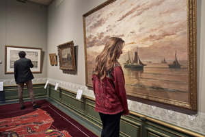 Vrouw kijkt naar een schilderij in De Mesdag Collectie