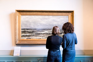 Twee mensen kijken naar een schilderij in De Mesdag Collectie